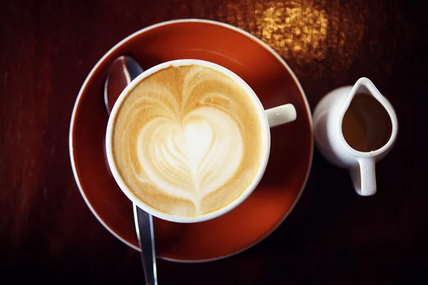 Café quente com leite na cafeteria na mesa de madeira — Fotografia de Stock