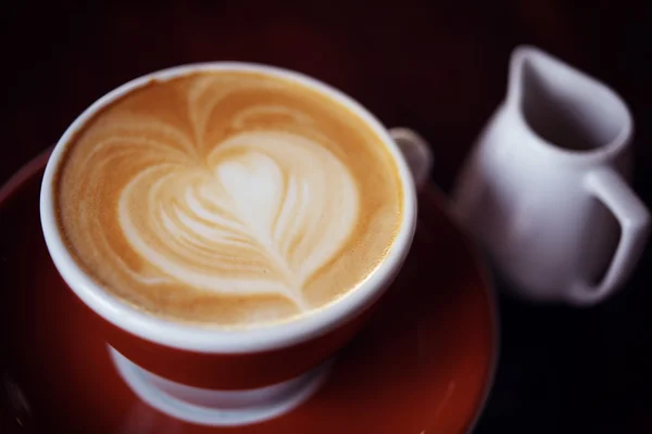 Café quente com leite na cafeteria na mesa de madeira — Fotografia de Stock