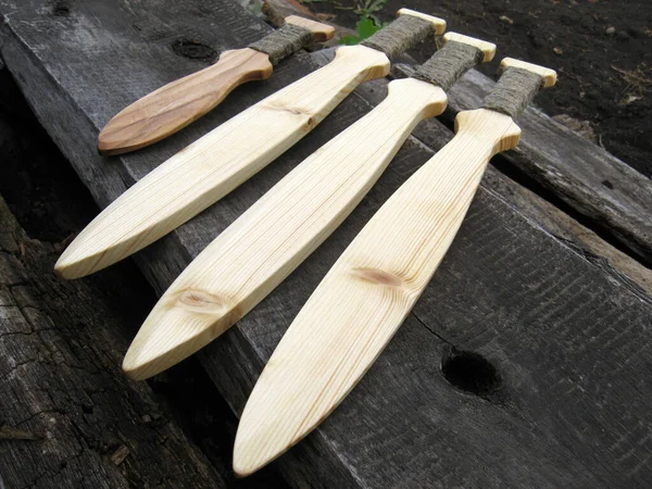 濃い自然を背景に四本の手作りの木製のおもちゃの剣 — ストック写真
