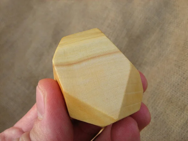 人の指の中のツミの石のおもちゃのための木製の石の背景 — ストック写真