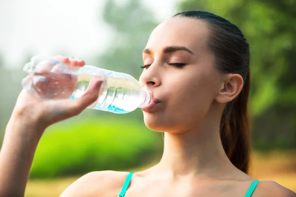 Una ragazza sportiva beve acqua — Foto Stock