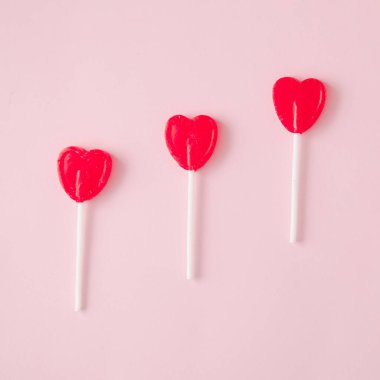 Pastel pembe arka planda lolipoplar. Asgari estetik.