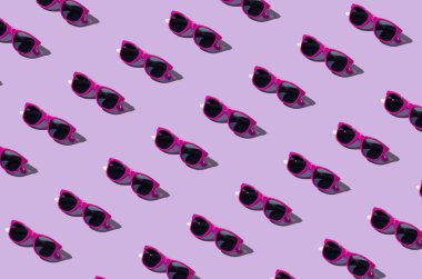 Creative pattern made of sunglasses on pastel purple background. Authentic retro concept.