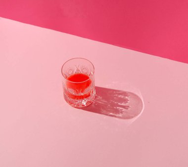 Pastel pembe arka planda bir bardak içecekle yapılmış otantik yaz düzeni. Yaratıcı asgari kavram.