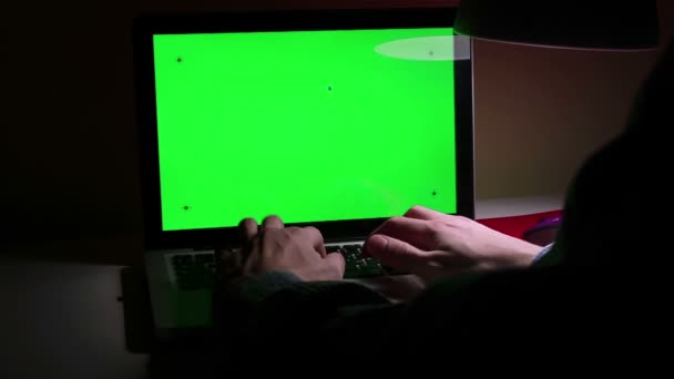 En man använder en bärbar dator på sitt skrivbord. — Stockvideo