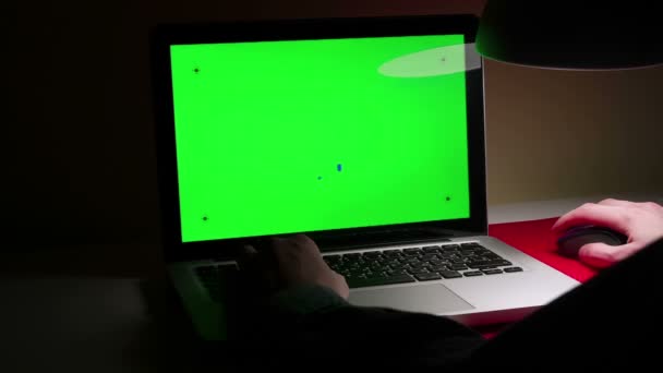 Ένας άνθρωπος που χρησιμοποιούν ένα φορητό υπολογιστή στην επιφάνεια εργασίας του. — Αρχείο Βίντεο