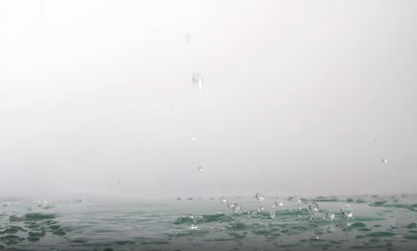 Gotas cai na água — Fotografia de Stock