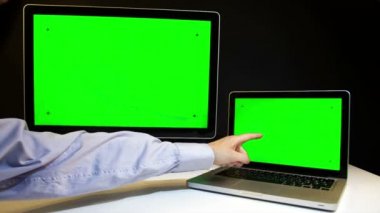 Laptop ve ekran üzerinde çalışan erkeğin yeşil bir ekran ile