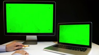 Laptop ve ekran üzerinde çalışan erkeğin yeşil bir ekran ile