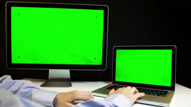 Uomo che lavora sul computer portatile e display con uno schermo verde — Video Stock