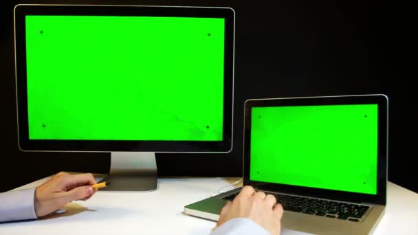 Hombre trabajando en el ordenador portátil y la pantalla con una pantalla verde — Vídeos de Stock