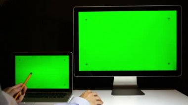 Laptop ve ekran üzerinde çalışan erkeğin yeşil bir ekran ile