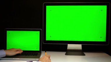 Laptop ve ekran üzerinde çalışan erkeğin yeşil bir ekran ile