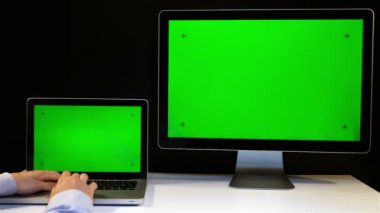 Laptop ve ekran üzerinde çalışan erkeğin yeşil bir ekran ile