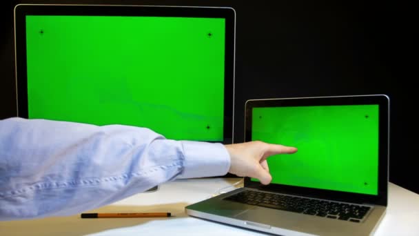 Uomo che lavora sul computer portatile e display con uno schermo verde — Video Stock