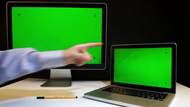 Человек, работающий над ноутбуком и дисплеем с зеленым экраном — стоковое видео