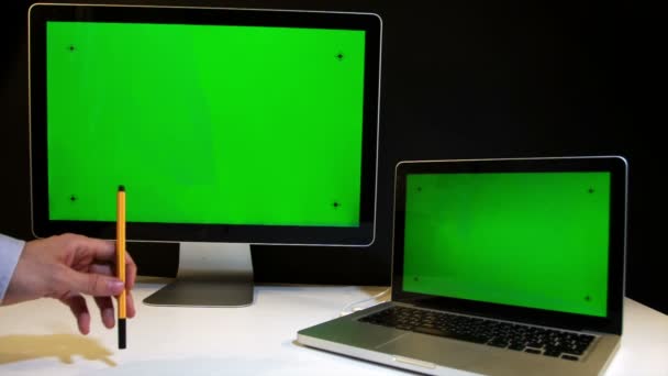 Uomo che lavora sul computer portatile e display con uno schermo verde — Video Stock