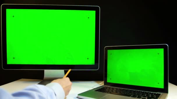 Hombre trabajando en el ordenador portátil y la pantalla con una pantalla verde — Vídeo de stock