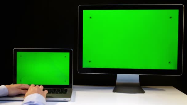 Uomo che lavora sul computer portatile e display con uno schermo verde — Video Stock