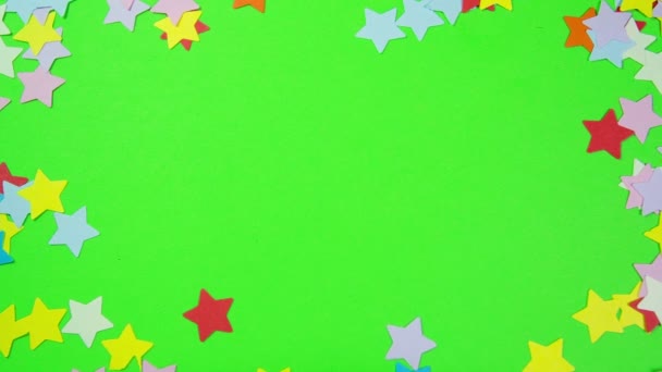 Estrelas multicoloridas moldadas em uma tela verde — Vídeo de Stock