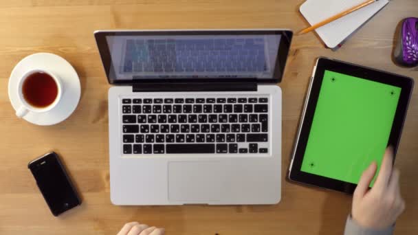 Usando Laptop y Tablet PC con una pantalla verde en el escritorio — Vídeos de Stock