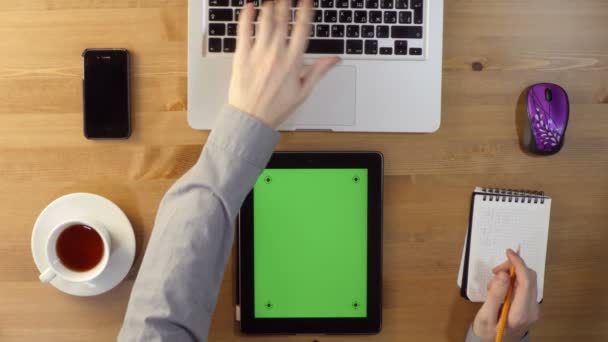 Usando Laptop y Tablet PC con una pantalla verde en el escritorio — Vídeos de Stock