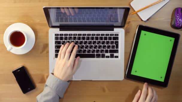 Utilisation d'un ordinateur portable et tablette PC avec un écran vert au bureau — Video