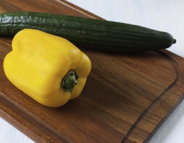 sarı biber ve yeşil salatalık ile tahta kesme
