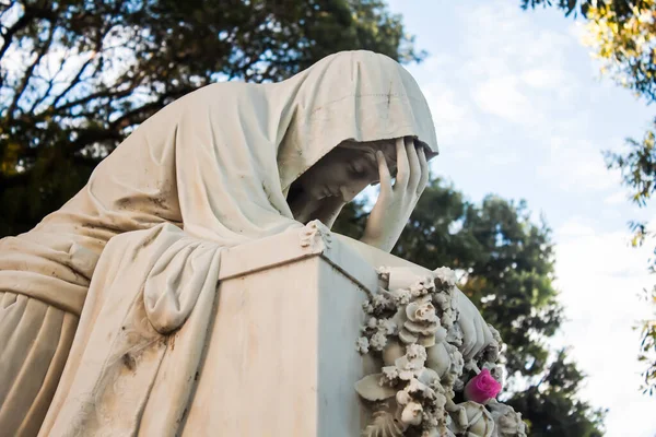 A marble grave statue of a mourning woman at the Campo Santo Necropolis in Salvador, Brazil.