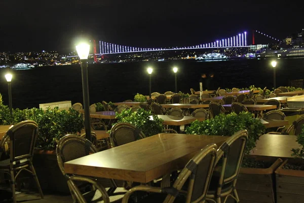 夜间在海边的咖啡店 看见灯火辉煌的桥 — 图库照片
