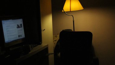 Odada sarı abajur var. bilgisayar.