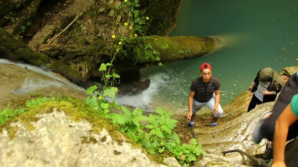 Jongen Met Een Rode Hoed Probeert Waterval Het Bos Beklimmen — Stockfoto