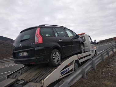 Siyah bir araba yolda bozulmuştu. Çekiciye yerleştirilmiş..