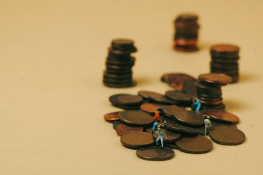 Ekonomi ve iş: sarı arkaplan üzerinde minyatür işçiler