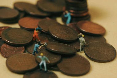 Ekonomi ve iş: sarı arkaplan üzerinde minyatür işçiler