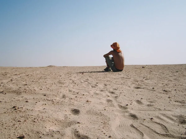 Ένας Άντρας Που Κάθεται Στην Έρημο Σαρώνει Τον Ορίζοντα — Φωτογραφία Αρχείου