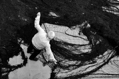 Balıkçı balık ağında çalışıyor.