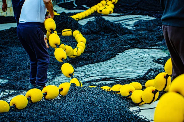 Balıkçı balık ağında çalışıyor.
