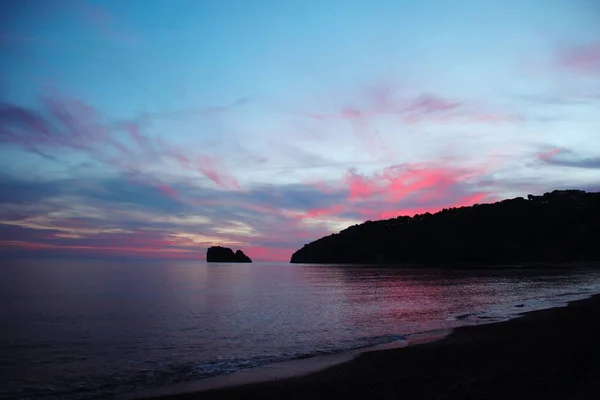 Gün batımında deniz ve kıyı manzarası