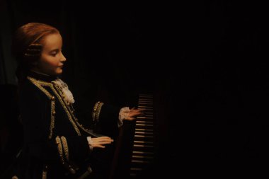 CZECH REPUBLIC, PRAGUE: JUNE 13 2015: Prague wax museum, little Amadeus Mozart at the piano