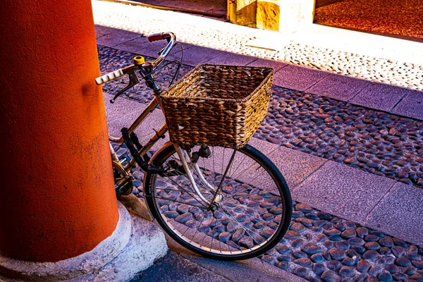 Detal Roweru Wiklinowym Koszem Opartym Kolorową Kolumnę Brukowaną Drogą Zabytkowe — Zdjęcie stockowe