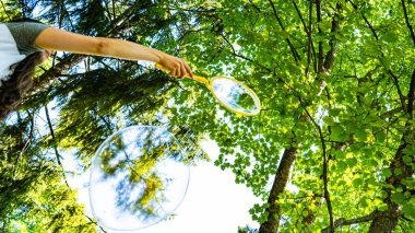 Kız yeşil parkta dev kabarcıklar yaratıyor.