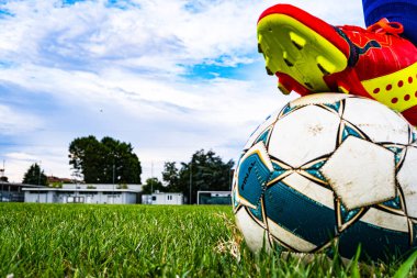 Futbol sahasında topa basan futbolcu ayağının altında gol var..