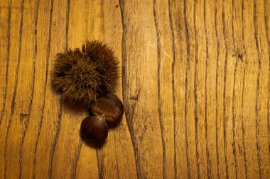 Sonbahar detayları. Tahta masada kabuklu kestaneler