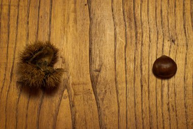 Sonbahar detayları. Tahta masada kabuklu kestaneler