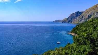 Cilento sahili, Scario. Campania, İtalya. Gök mavisi deniz, sahil ve kayık manzarası.