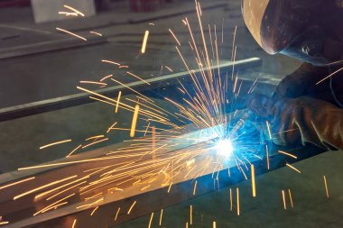 Adam metali gaz ve elektrik kaynaklarıyla işliyor. Metal üzerine kaynak..