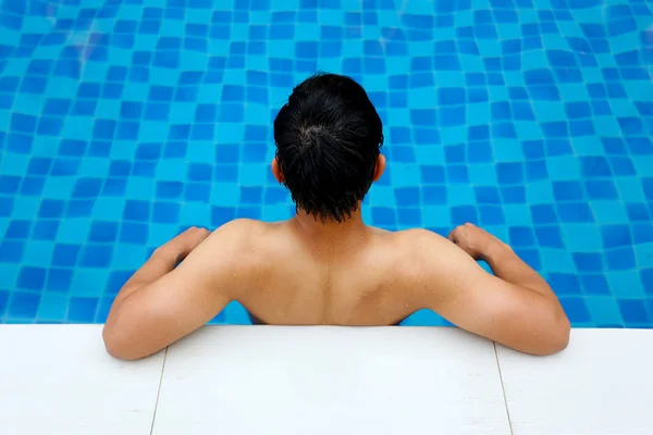 Asyalı gencin rahatlatıcı bir havuz kenarı otel bir yüzme havuzunda arkadan görünüm