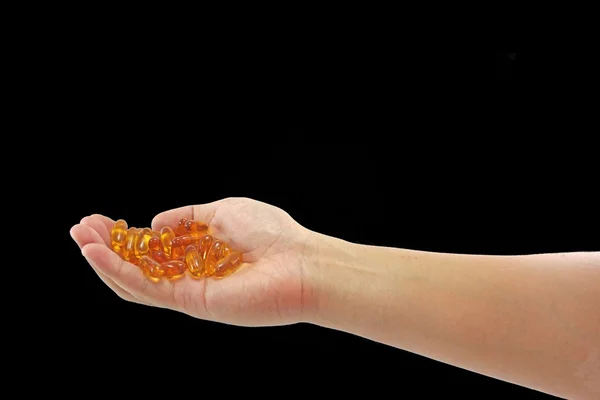 Balık yağı kapsülleri holding eller arka plan geri