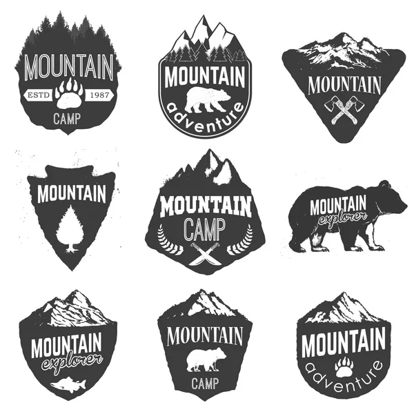 Plantillas de insignias de campamento de montaña con montañas y árboles aislados — Vector de stock